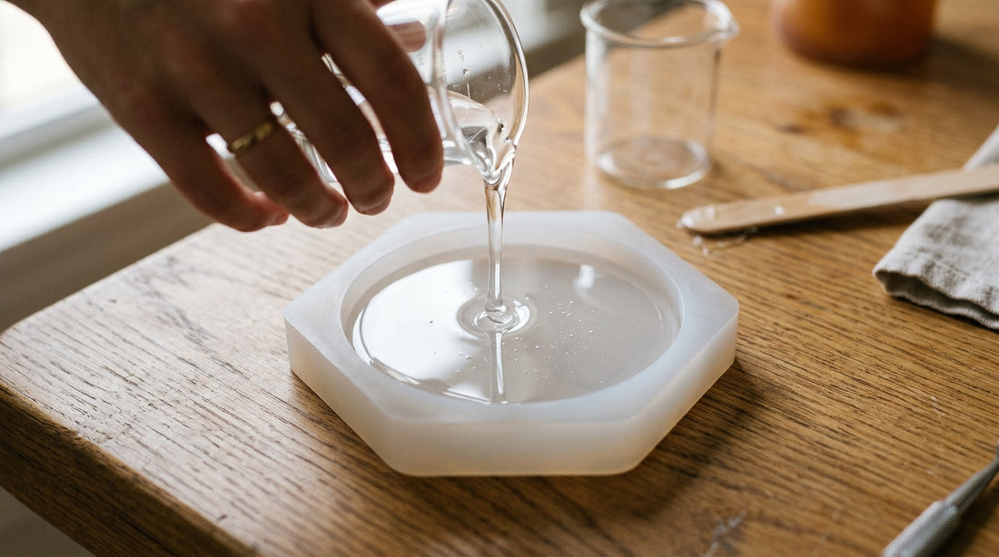 Clear casting resin poured into a soft translucent white silicone mold on a craft table