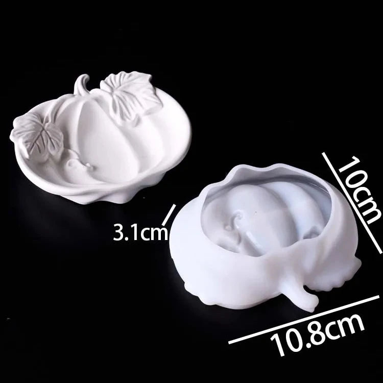 Two white pumpkin-shaped silicone or ceramic molds shown on a black background, with dimension labels (3.1cm, 10cm, 10.